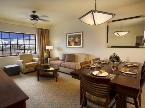 A cozy living and dining room with a sofa, chairs, coffee table, dining table set, and a large window. End sentence.