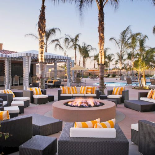A luxurious resort pool area with palm trees, lounge chairs, and a sunny, resort-style courtyard.