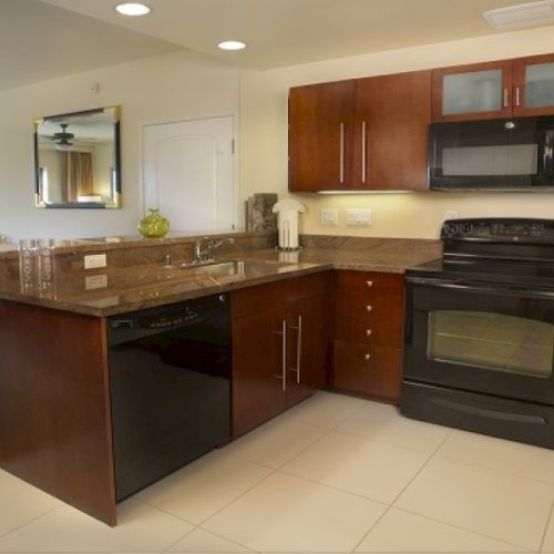 A modern kitchen with a central island, warm wood cabinetry, stainless appliances, and a casual dining area.